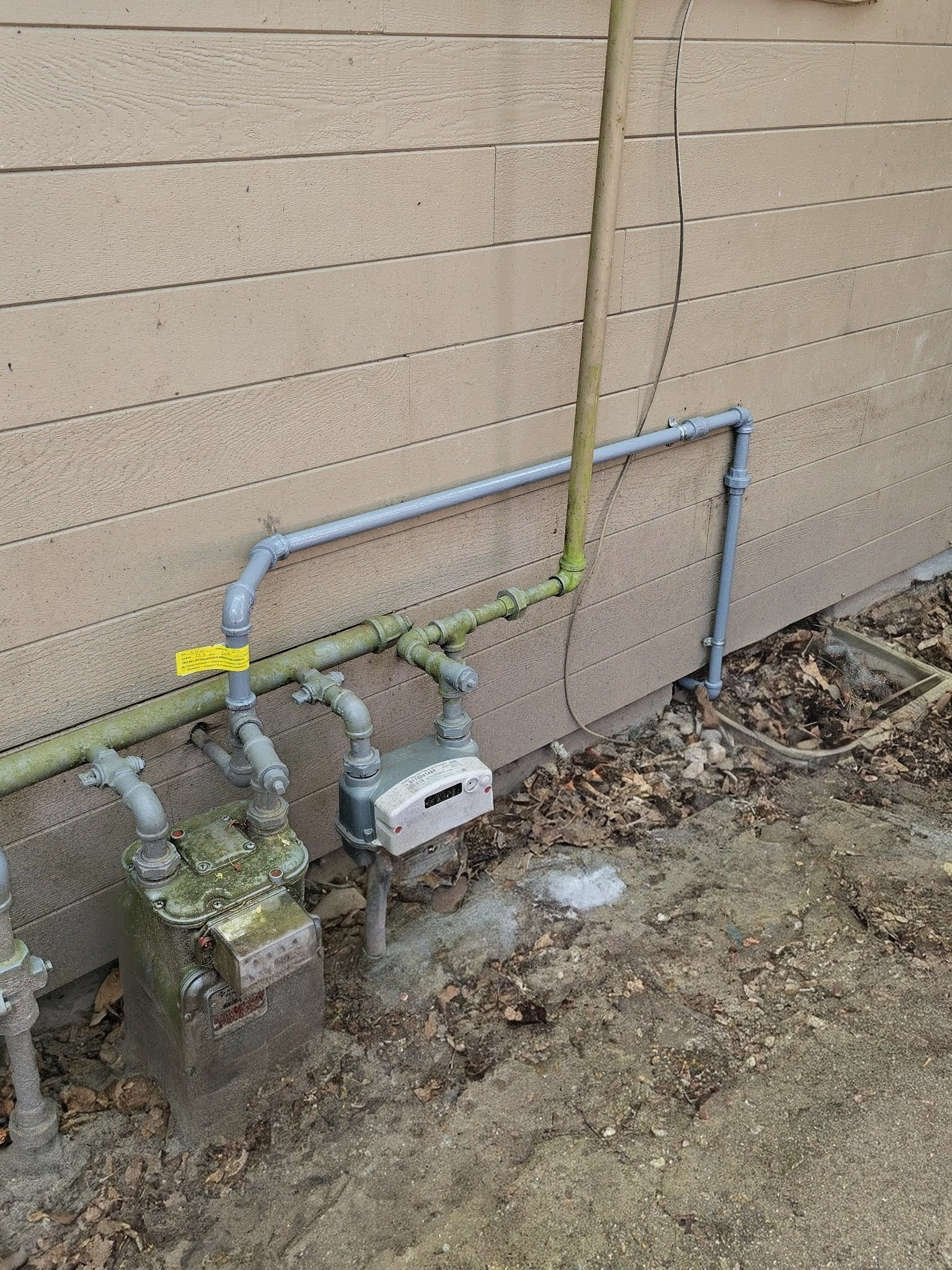 Exterior gas meter and piping beside a house